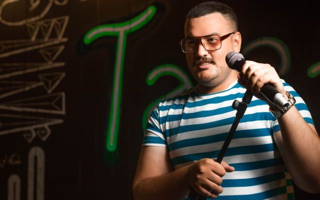 Comedian performing on stage with microphone