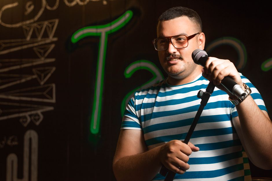 Comedian performing on stage with microphone