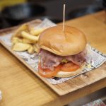 Plate of American-style burger and fries on restaurant table