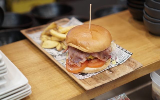 Plate of American-style burger and fries on restaurant table