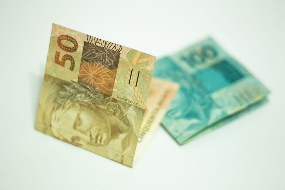Person reviewing bank savings statements and euro coins