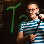 Comedian performing on stage with microphone
