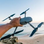Person operating a small camera drone outdoors