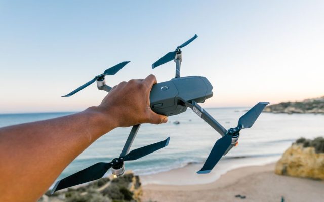 Person operating a small camera drone outdoors