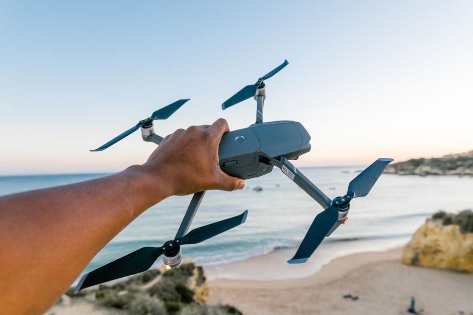Person operating a small camera drone outdoors