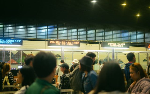 Travellers queuing at an airport border control checkpoint
