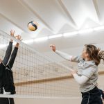 Volleyball players competing in a sports hall during a tournament