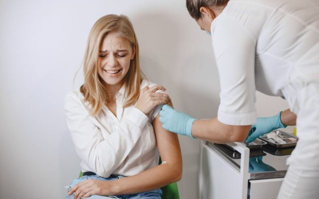 Nurse administering HPV vaccine injection to young woman