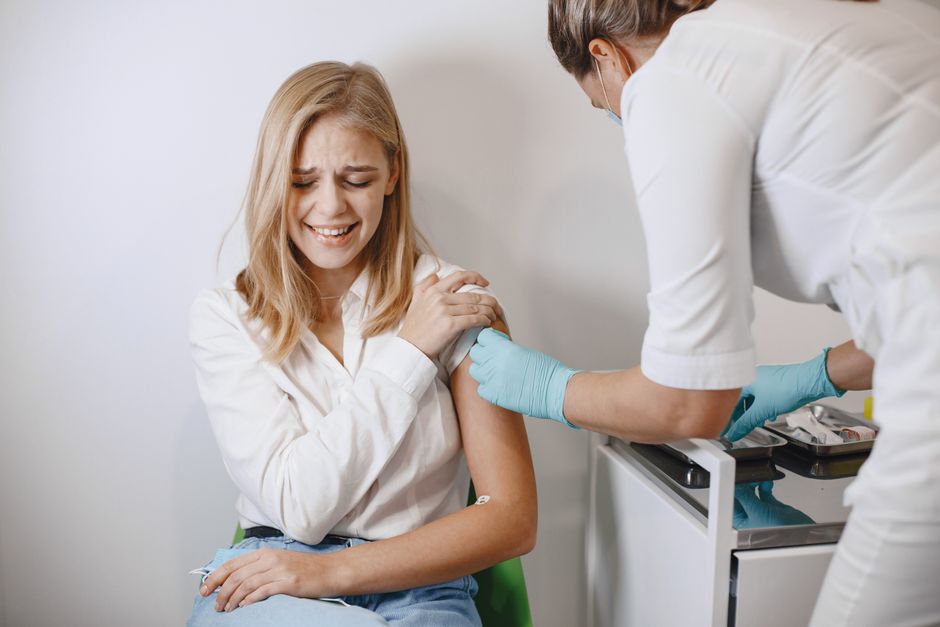 Nurse administering HPV vaccine injection to young woman